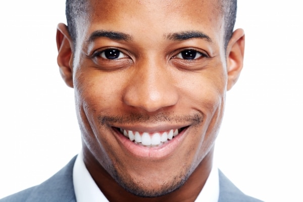 headshot of man smiling widely showing off his veneers