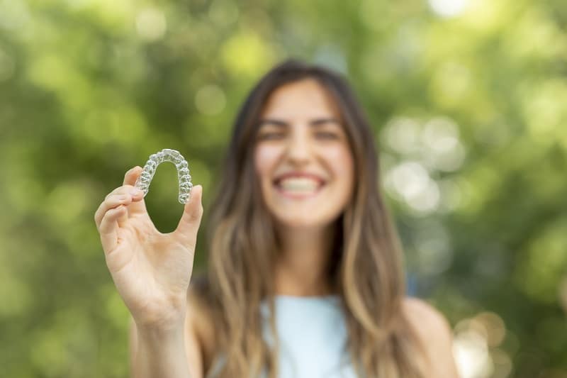 Boulder teen holding Invisalign clear braces 