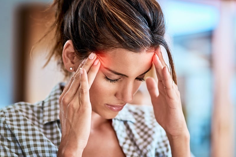 Woman suffering from TMJ headache in Boulder