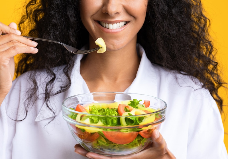 Woman eating salad for her dental health