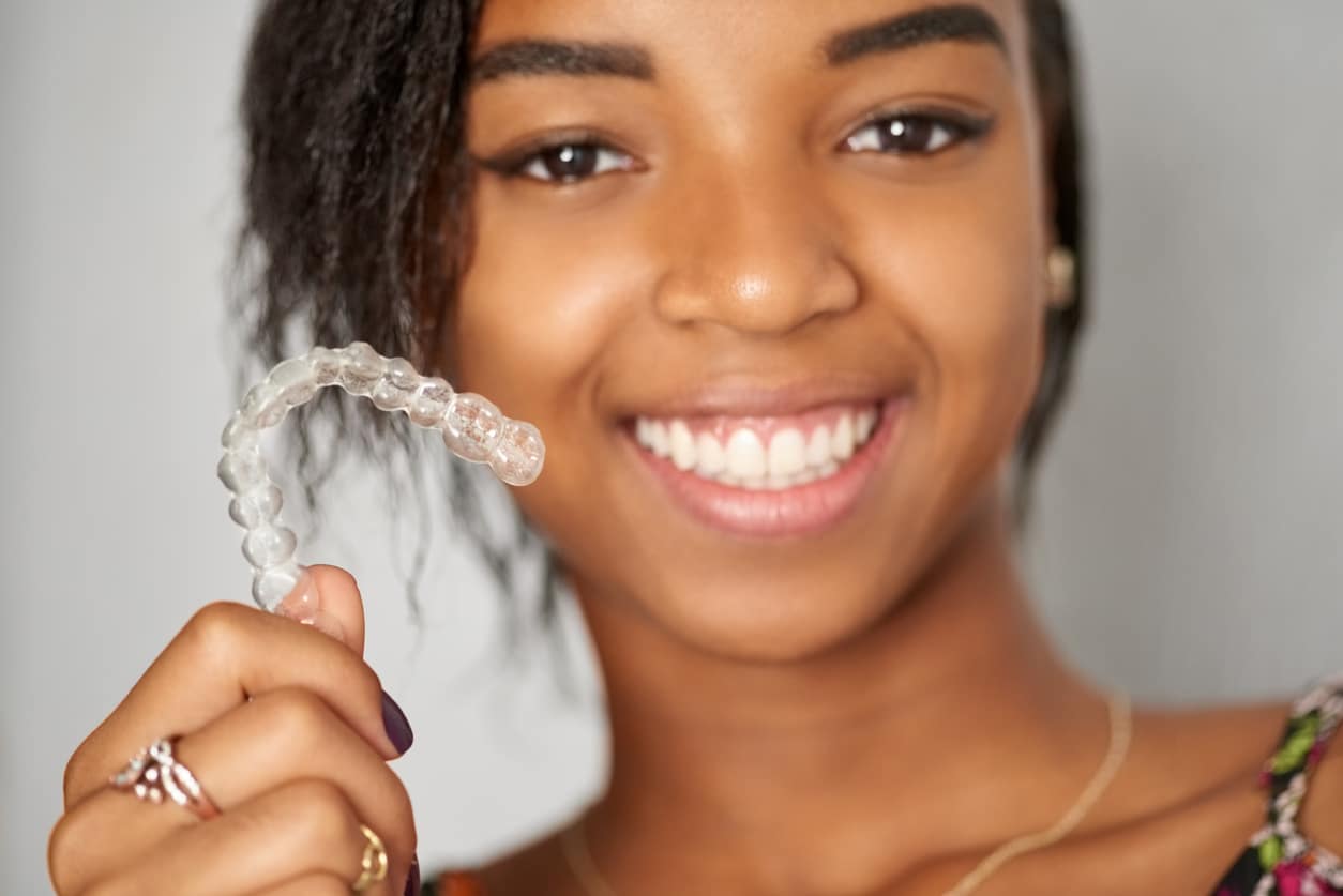 holding up clear braces Invisalign dentist near Boulder CO