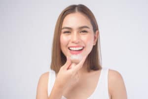 smiling woman holding invisalign braces