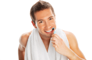 Man brushing teeth isolated on white