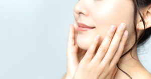 A woman holding her jaw because she’s experiencing TMJ pain