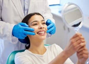 Woman in dentist chair smiling after full mouth reconstruction in Boulder, CO