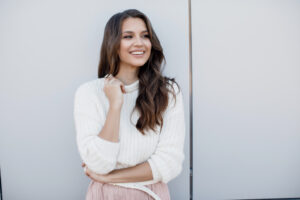 Young woman in winter clothes with bright white smile from teeth whitening in Boulder, CO